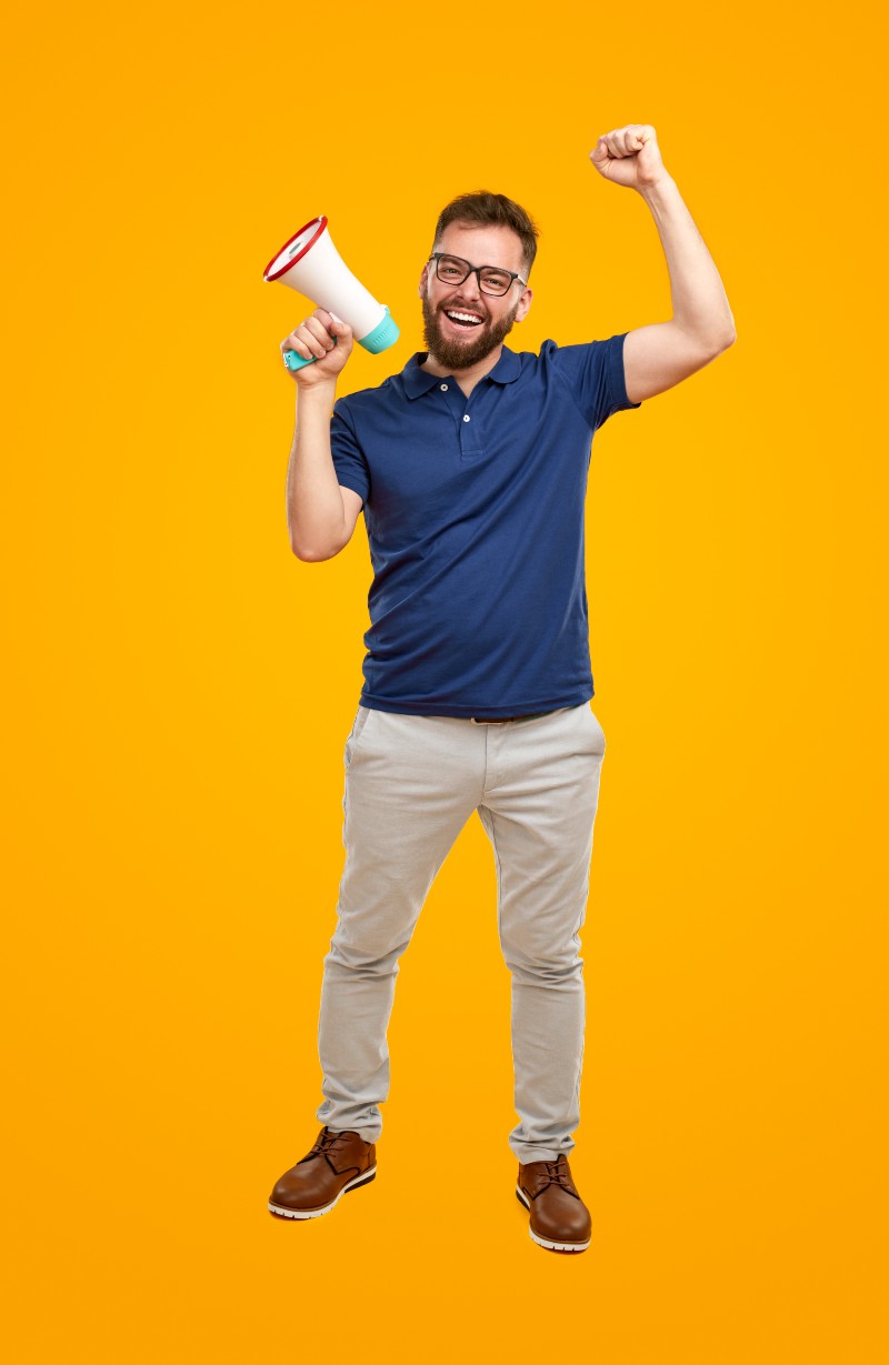 positive-man-shouting-in-megaphone-in-studio-2023-11-27-04-55-31-utc